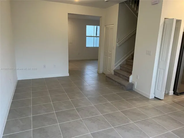 a view of an empty room with a fireplace and a window