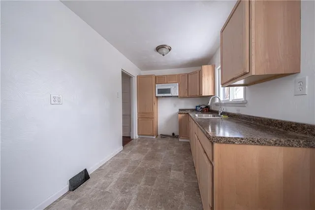 a kitchen with stainless steel appliances granite countertop a sink and a microwave