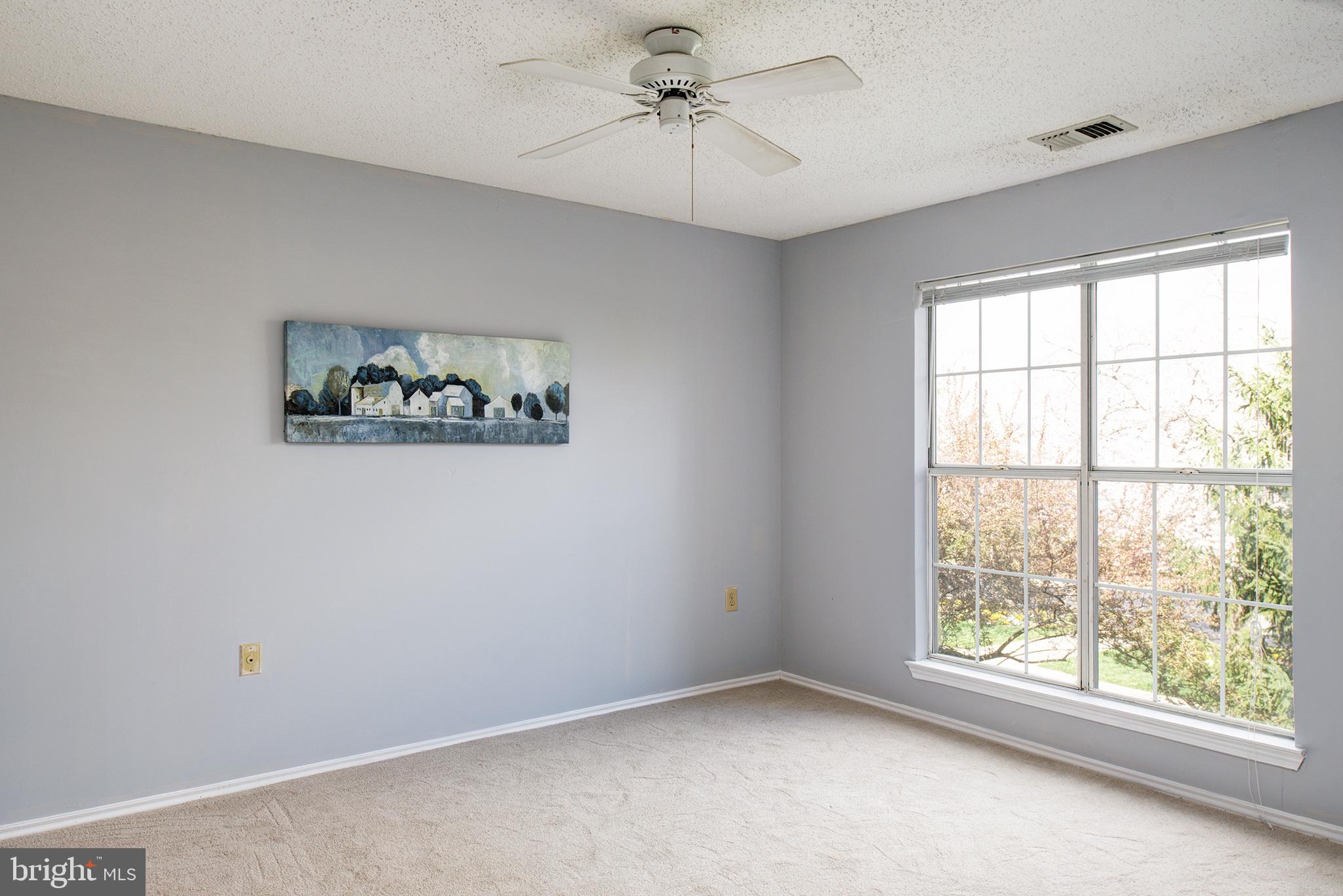 20951 Timber Ridge Terrace, Unit 202 Ashburn, VA 20147 - Photo 5 of 16 Owner's bedroom with ceiling fan and double window