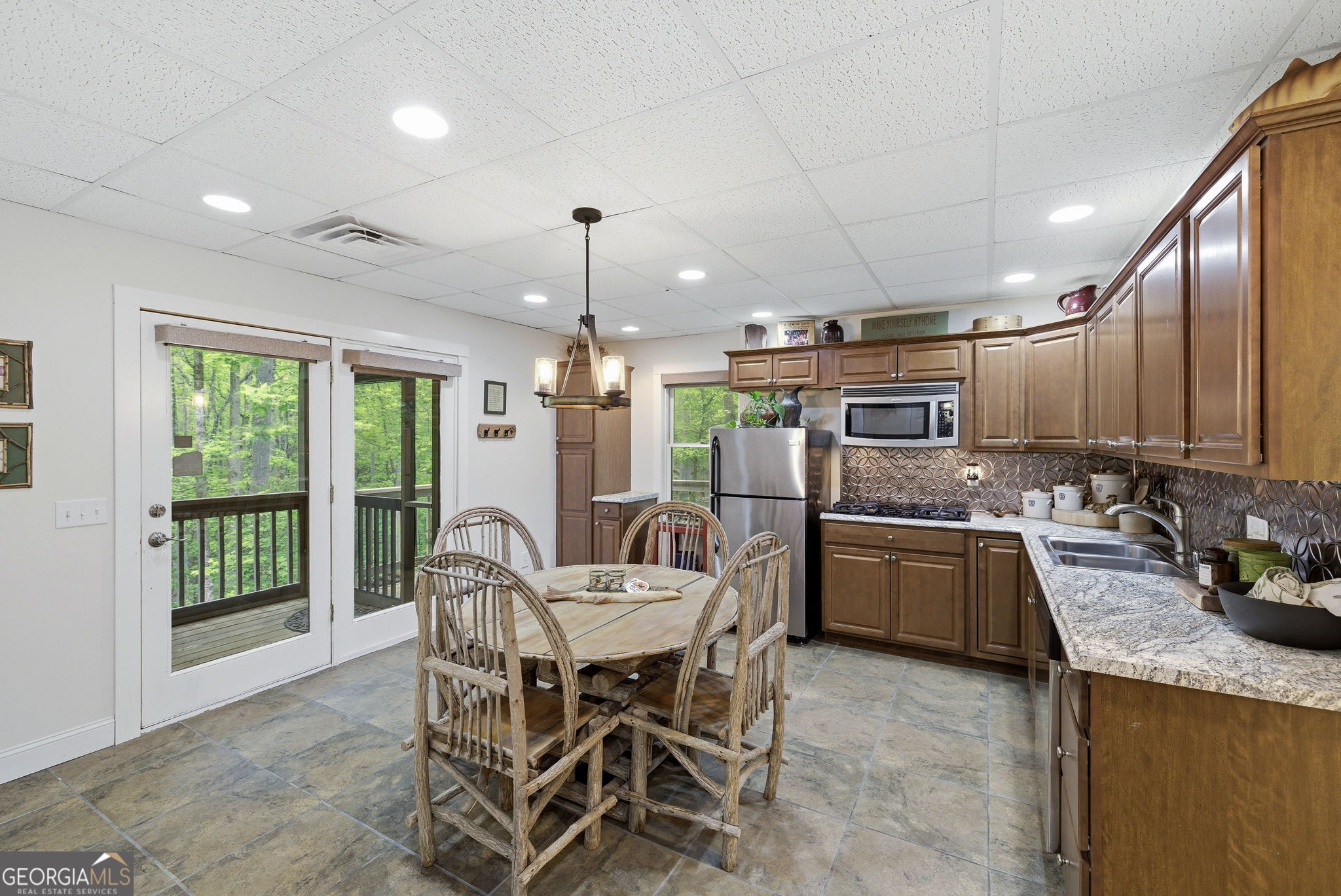 634 Little Hawk Road Sautee Nacoochee, GA 30571 - Photo 34 of 54 a kitchen with stainless steel appliances granite countertop a sink a stove a refrigerator cabinets and chairs