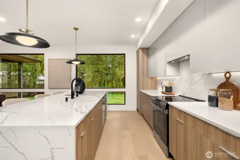 a large kitchen with kitchen island a large window in it