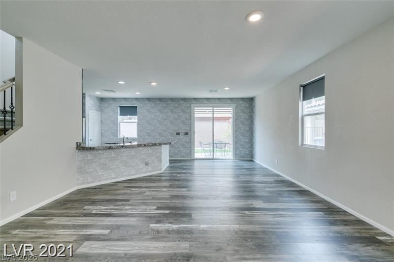 5475 Ordesa Valley Road Las Vegas, NV 89148 - Photo 32 of 35 A versatile open-concept living space features durable wood-look flooring and a bright sliding glass door leading to the outdoors.