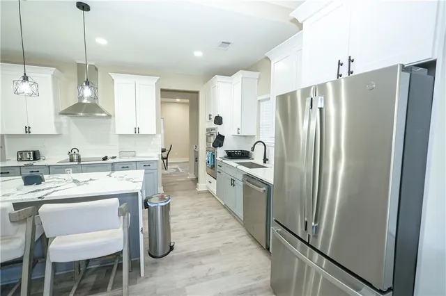 a kitchen with a dining table chairs refrigerator and cabinets