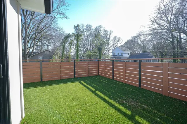 a view of a yard with wooden fence