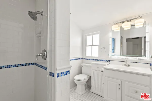 a bathroom with a granite countertop sink a toilet and a mirror