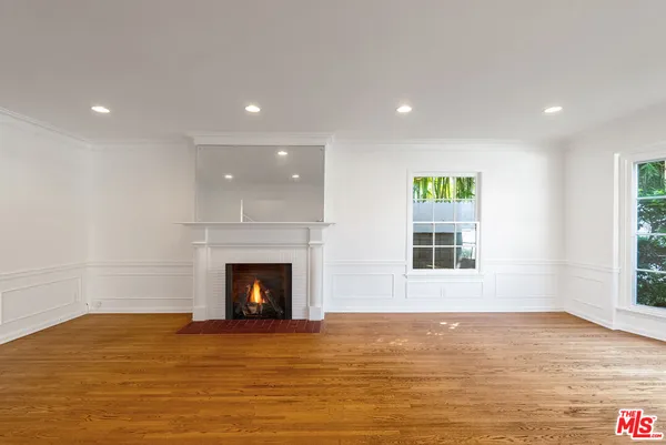 a view of an empty room with a fireplace and a window