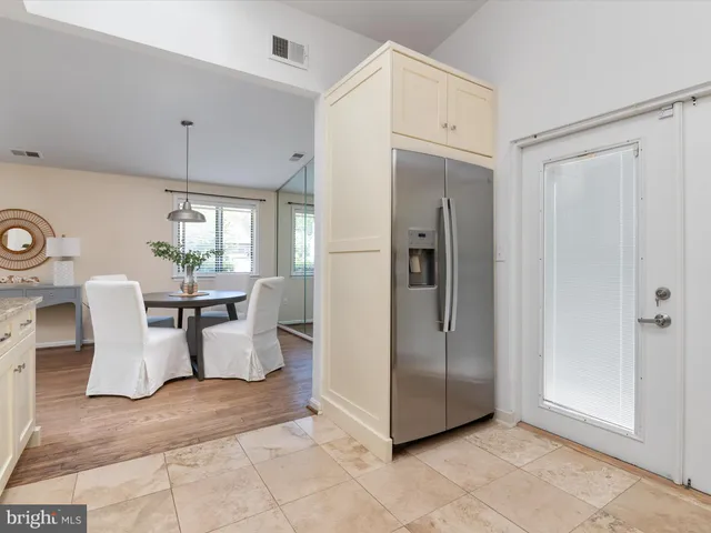 a view of a kitchen with dining area and refrigerator