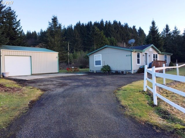 8155 Burbank Road Tillamook, OR 97141 - Photo 1 of 21 a view of a house with backyard and trees in the background