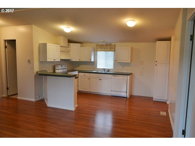 8155 Burbank Road Tillamook, OR 97141 - Photo 13 of 21 a kitchen with stainless steel appliances granite countertop a sink and cabinets