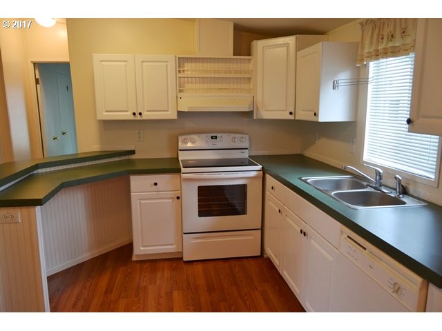 8155 Burbank Road Tillamook, OR 97141 - Photo 2 of 21 a kitchen with a sink stove and cabinets