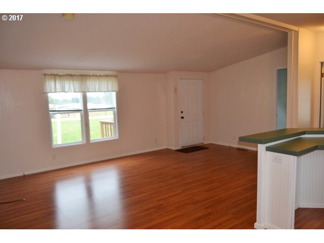 8155 Burbank Road Tillamook, OR 97141 - Photo 3 of 21 a view of an empty room with wooden floor and a window