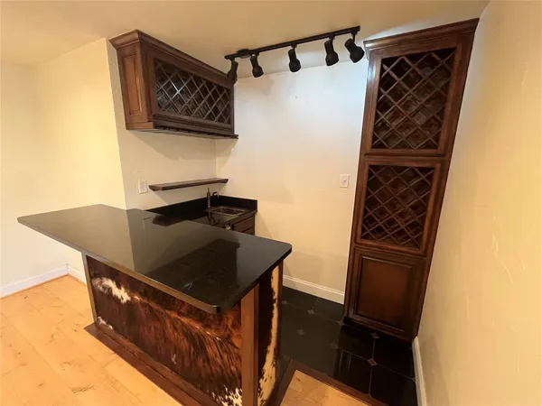 a view of an empty room with a window and a kitchen