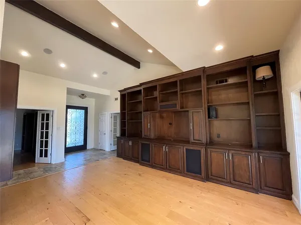 a view of an empty room with a window and a kitchen