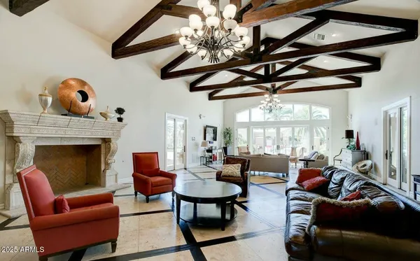 a living room with furniture a chandelier and a fireplace
