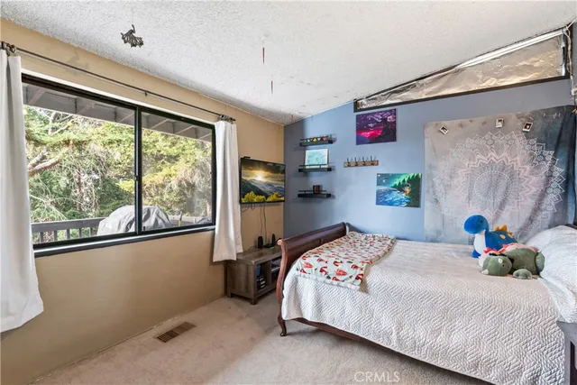 a bedroom with a bed and a dresser next to a window