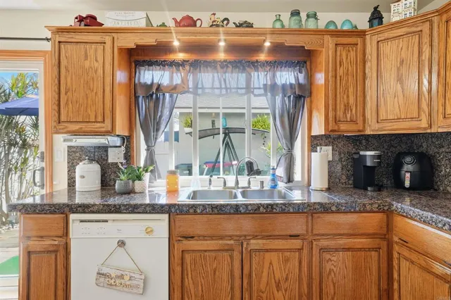 a kitchen with granite countertop a sink a stove and cabinets
