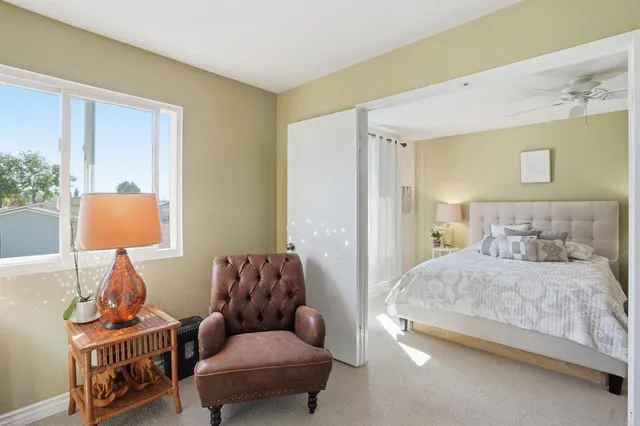 a bedroom with a bed and a lamp on dresser