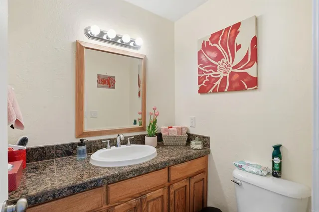 a bathroom with a granite countertop sink and a mirror