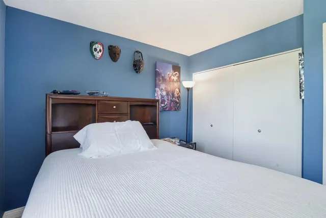 a bedroom with a bed and a refrigerator