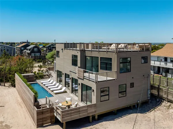 a roof deck with table and chairs a barbeque