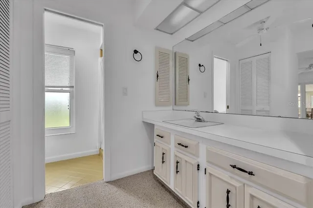 a spacious bathroom with a granite countertop sink and a mirror