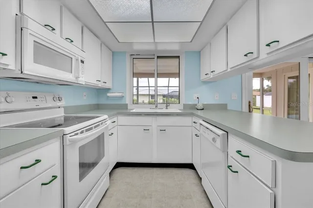 a kitchen with white cabinets and white appliances