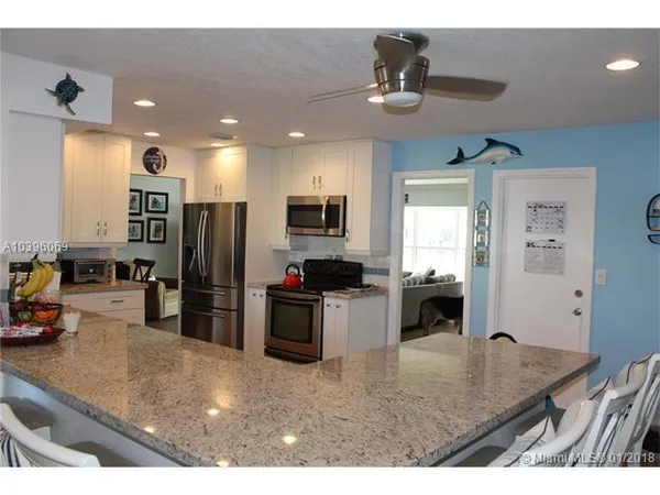 a kitchen with sink refrigerator and microwave