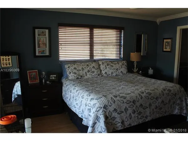 a bedroom with a bed dresser and a window