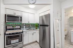 86-20 57th Road Queens, NY 11373 - Photo 14 of 21 Kitchen with white cabinets, light countertops, appliances with stainless steel finishes, and light tile patterned floors