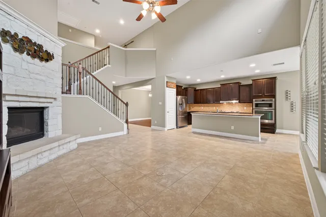 an empty room with a chandelier fan and a ceiling fan