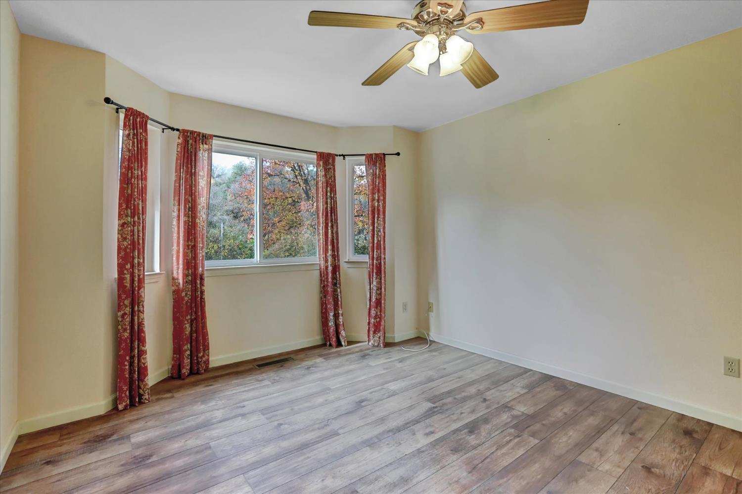 19310 John Born Road Penn Valley, CA 95946 - Photo 17 of 78 an empty room with wooden floor fan and windows