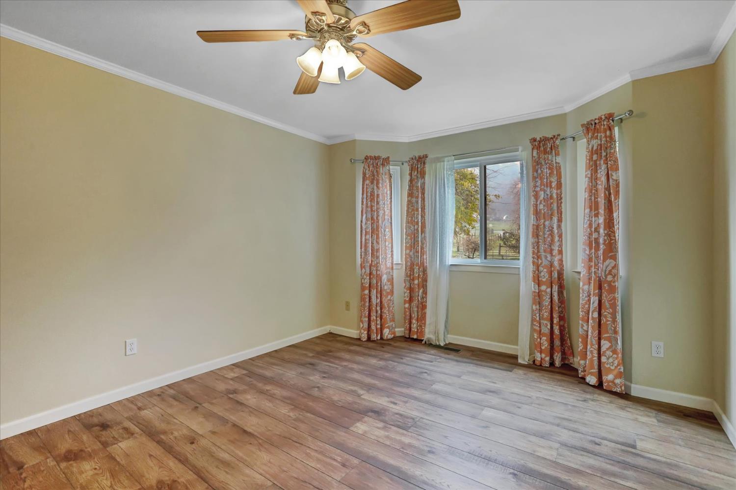 19310 John Born Road Penn Valley, CA 95946 - Photo 20 of 78 an empty room with wooden floor chandelier fan and windows