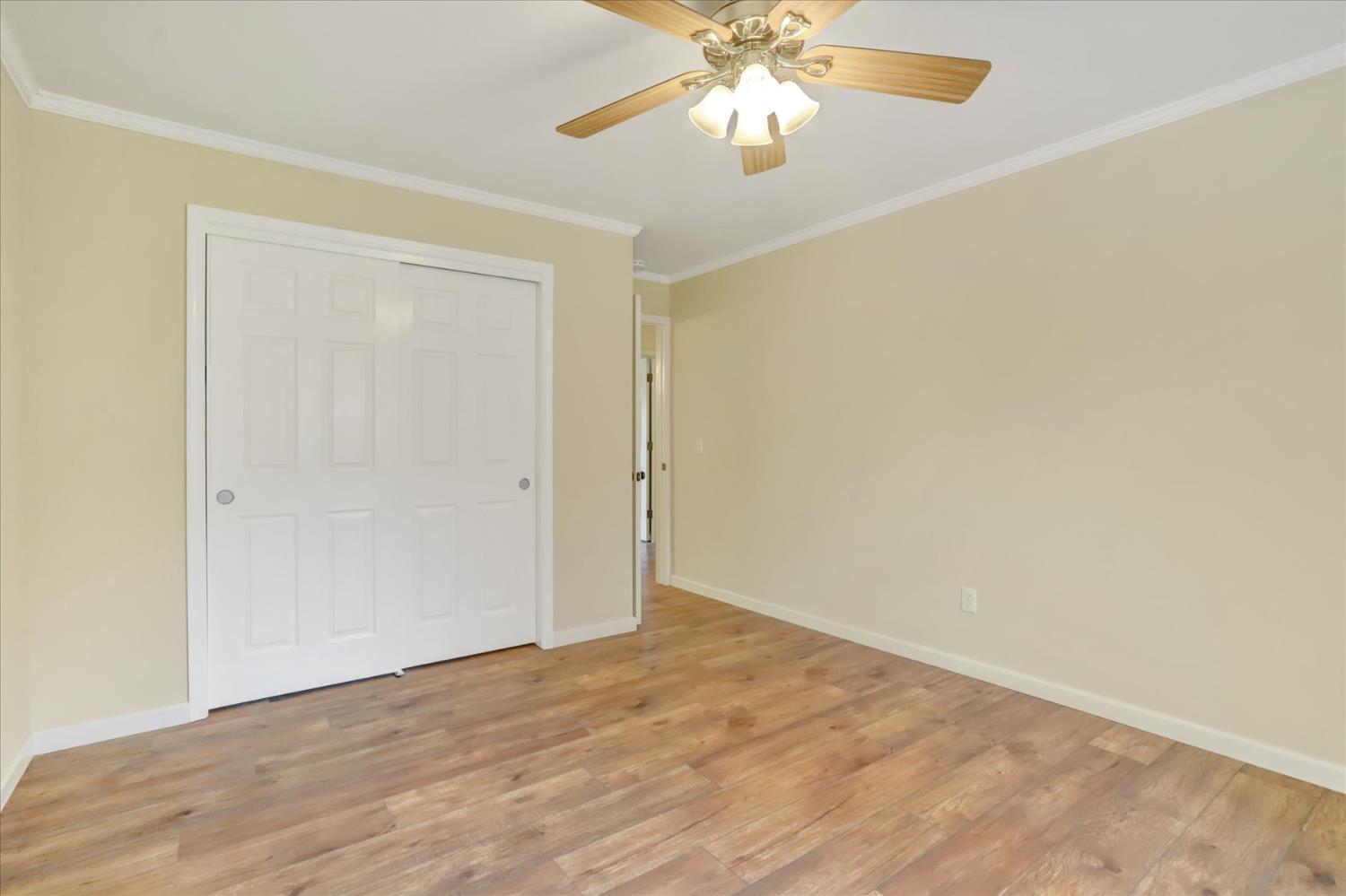 19310 John Born Road Penn Valley, CA 95946 - Photo 21 of 78 an empty room with a chandelier fan and wooden floor