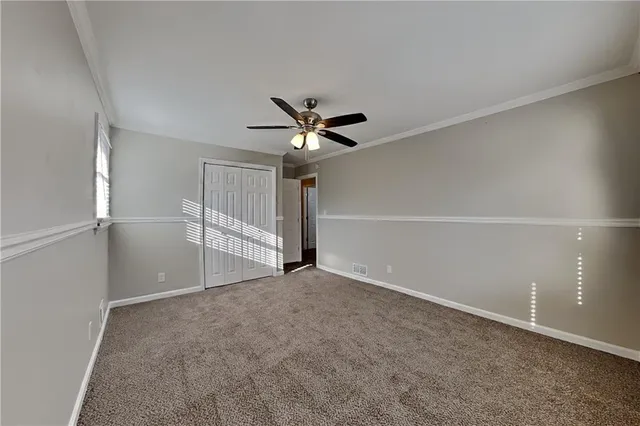 a view of an empty room with a ceiling fan