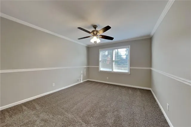 an empty room with windows and ceiling fan