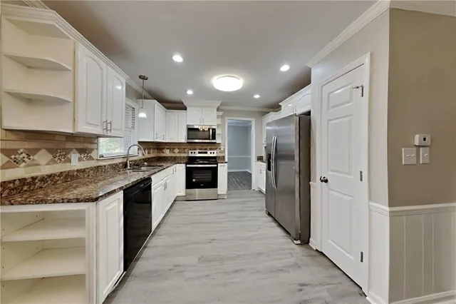 a large kitchen with stainless steel appliances granite countertop a refrigerator and a stove top oven