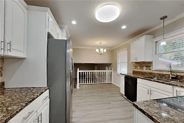 a kitchen with stainless steel appliances granite countertop a stove a sink and a refrigerator