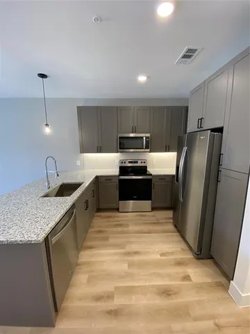 a kitchen with stainless steel appliances granite countertop a sink stove and refrigerator