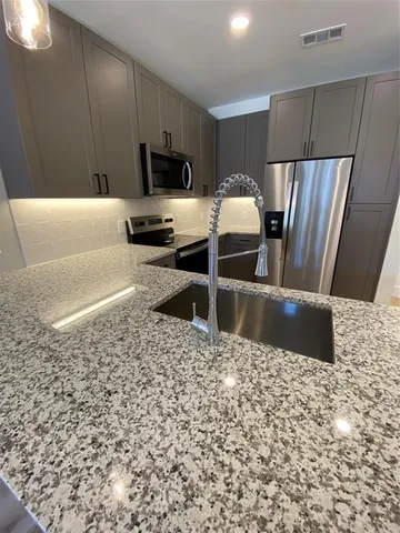 a kitchen with a sink a stove a microwave and refrigerator