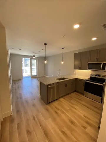 a large kitchen with a large counter top stainless steel appliances and cabinets