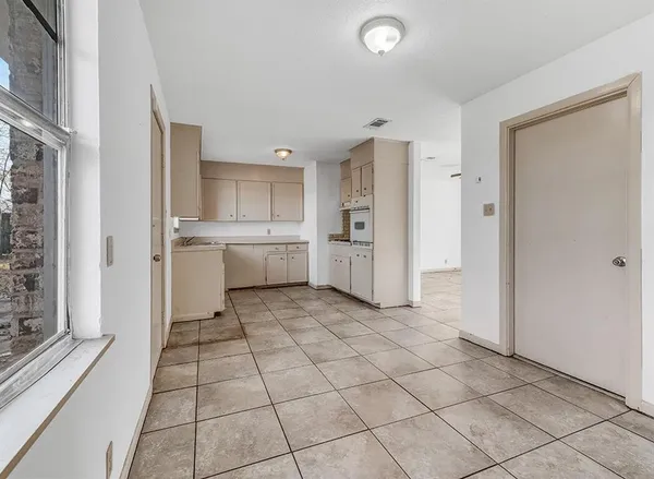 a kitchen with granite countertop a refrigerator and a stove top oven