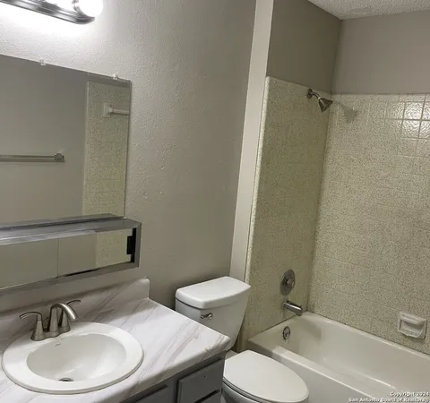 a bathroom with a sink toilet mirror and shower