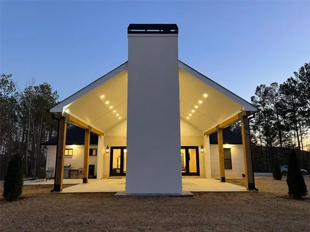 a view of a house with backyard and trees
