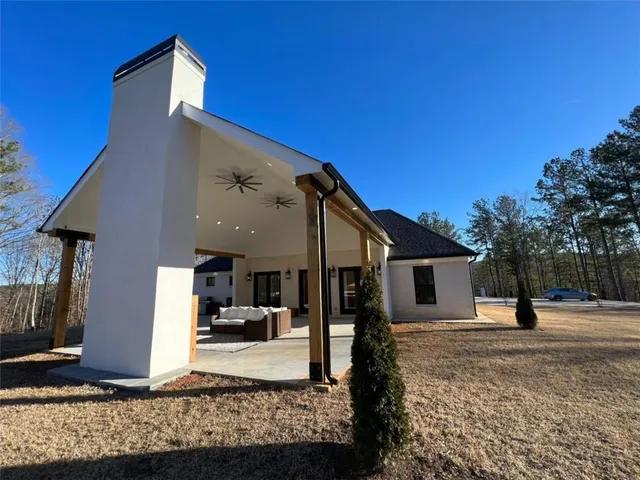 a living room with couches and kitchen view with wooden floor