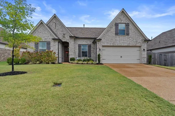 a front view of a house with a yard and garage
