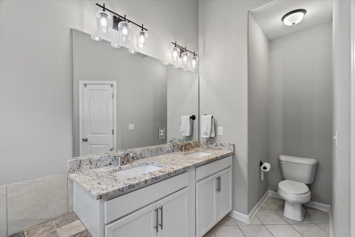 270 Whispering Ridge Drive Oakland, TN 38060 - Photo 11 of 27 a bathroom with a granite countertop sink a toilet and a mirror