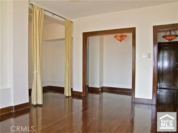 a view of empty room with wooden floor