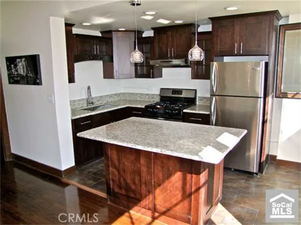 a kitchen with stainless steel appliances a stove a sink a refrigerator and cabinets