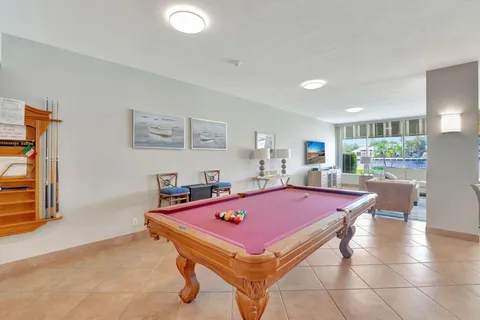 a room with pool table and windows