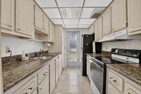 a kitchen with stainless steel appliances granite countertop a sink stove and refrigerator